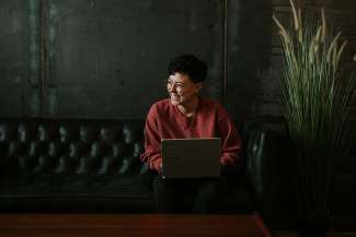 Vrouw met laptop - ook voor online giften kan je een fiscaal attest krijgen