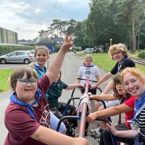 Kinderen met verstandelijke beperking en monitoren fietsen samen op een gocart