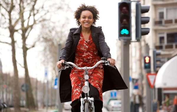 Vrouw op de fietst kijkt gelukkig naar de camera