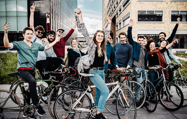 Groepje studenten op de fiets steekt de handen in de lucht