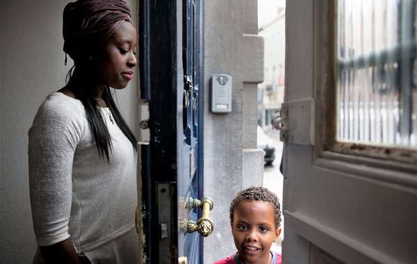 Mère et son fils à la porte de la maison d'Accueil pour femmes et familles de L'Ilot.