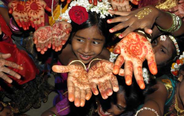 Kinderen tonen hun handen versiert met henna ter gelegenheid van het schoolfeest